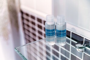 Two bottles of Quokka 360 shampoo on a glass shelf in a bathroom. - PARCO 13  (Lugano)