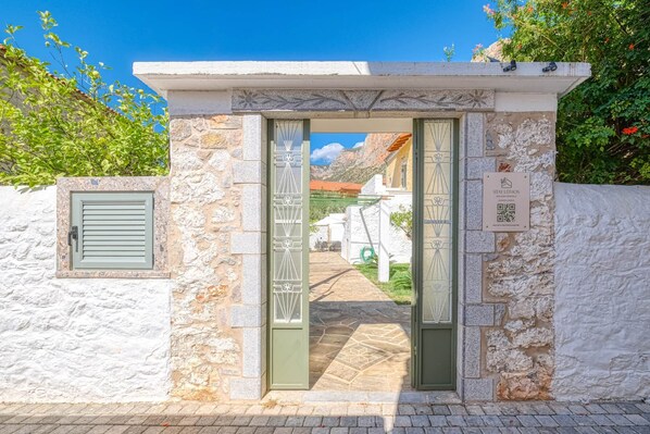 Una entrada de piedra con puerta y un cartel de Stay Litos alquileres vacacionales.