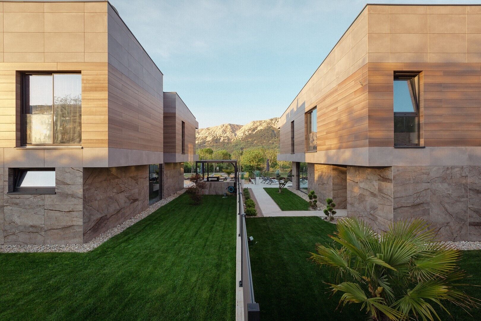 A modern two-story building with a symmetrical design, featuring large windows and a well-maintained lawn.