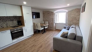 A compact living space with a kitchenette, dining area, and a sofa. - Modern equipped apartment in the  center of Baška, near the sea (Baska)