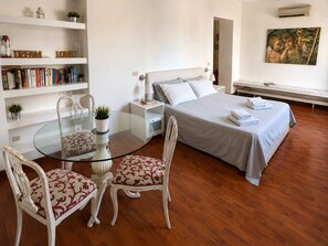 A bedroom with a bed, bedside table, lamp, and a painting on the wall. - Terrazzo Frattina Penthouse with terrace close to Spanish Steps (Roma)