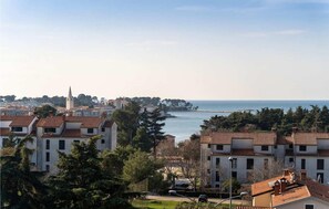 A coastal town with traditional buildings, a prominent church spire, and a view of the sea. - Lovely apartment in Porec with WiFi (Porec)