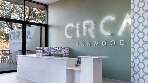 A reception desk with a computer and a photo collage. The wall behind has the text "CIRCA LYNNWOOD".