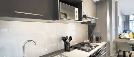 A modern kitchen with stainless steel appliances, a built-in oven, and a large sink.