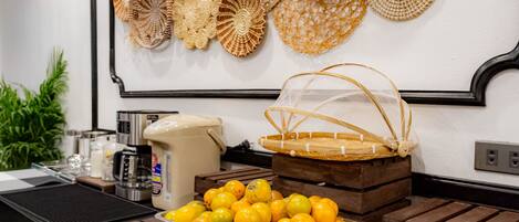 A buffet setup with a tray of lemons, a coffee maker, and a basket on wooden crates.