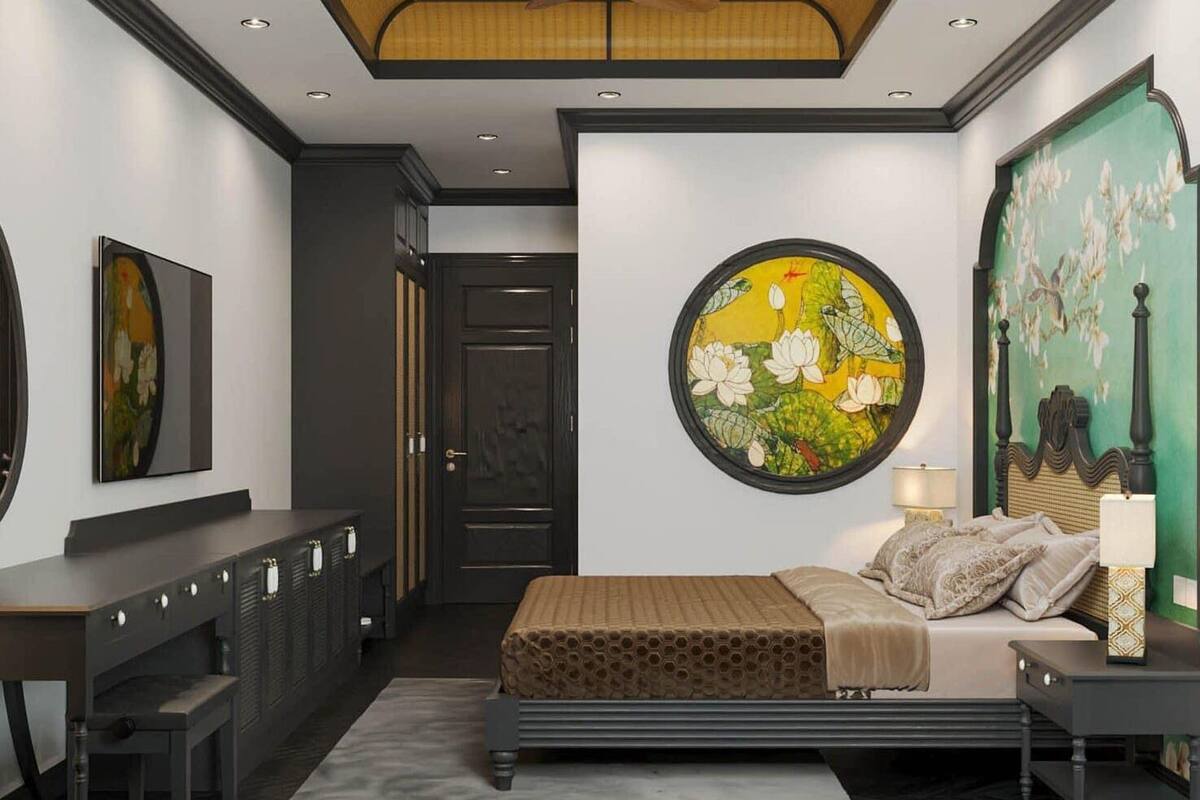 A bedroom with a bed, bedside table, lamp, and artwork on the wall.