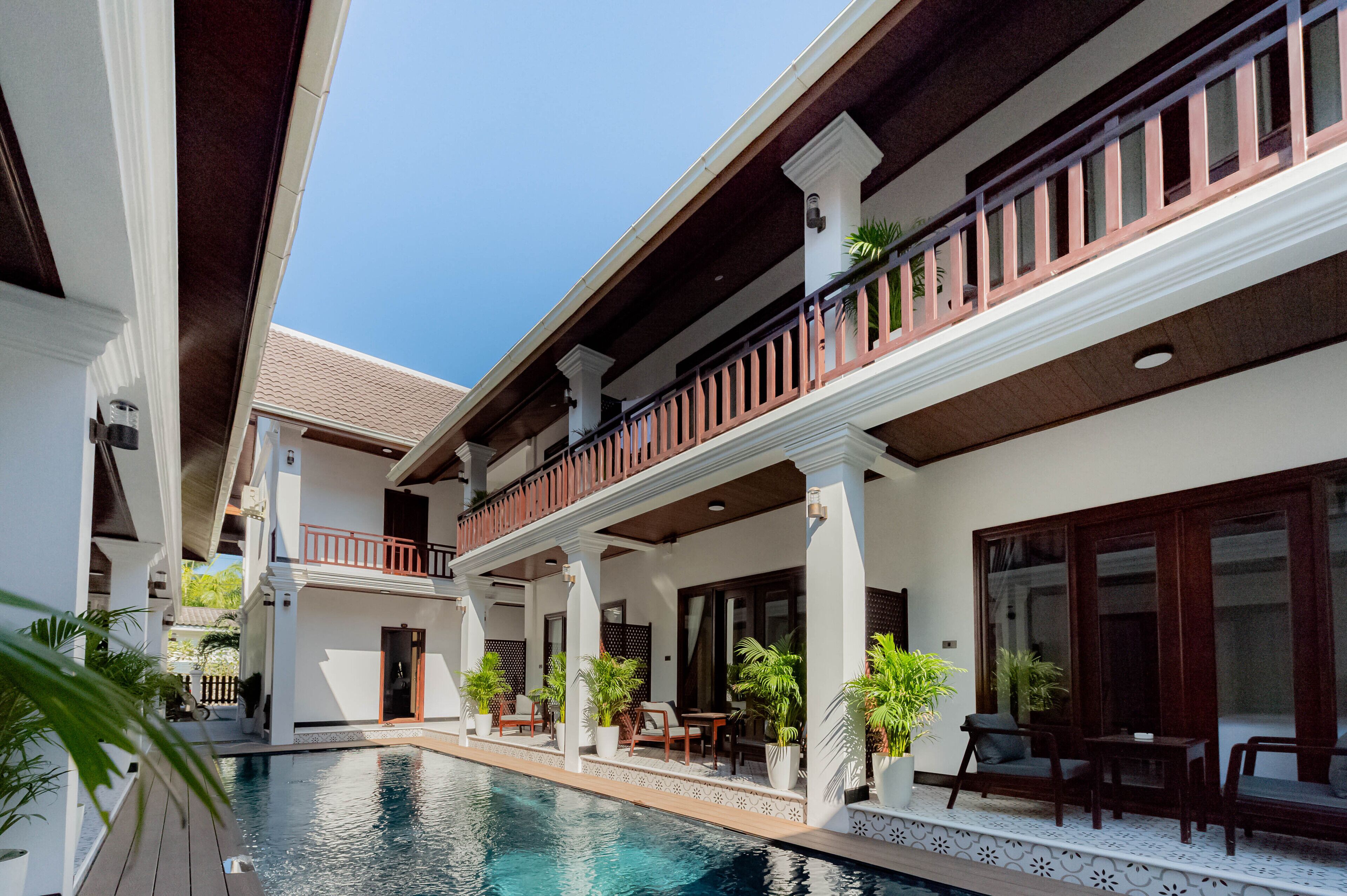 A poolside area with outdoor seating and a view of the pool.