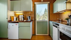 A compact kitchen with light green cabinets, a refrigerator, a coffee maker, and a sink. - 2 bedroom stunning home in Vordingborg (Vordingborg)