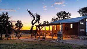 Un edificio rústico con porche cubierto, cimientos de piedra y fachada de madera.