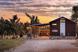 A rustic cabin with a covered porch, a stone foundation, and a sign reading 'Morning Star.' - Rockin' R - Morning Star Cabin (Fredericksburg)