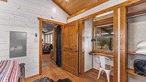 A wooden interior with a bed, a chair, and a wardrobe. - Rockin' R - Rustic Star Cabin (Fredericksburg)