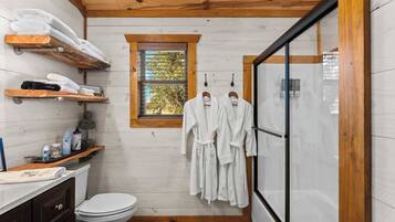 Un bagno con travi in legno, una finestra, un water e uno spazio doccia.