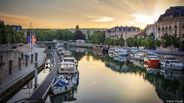A canal with boats docked along the sides, surrounded by buildings and trees. - Distinguished Townhouse, "L'Aparté" (Verdun)
