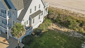A large, two-story house with a steeply pitched roof, a front porch, and a well-maintained lawn. - 6BR Oceanfront House in North Topsail Beach w Hot Tub, Community Pool, Sleeps 15 (North Topsail Beach)
