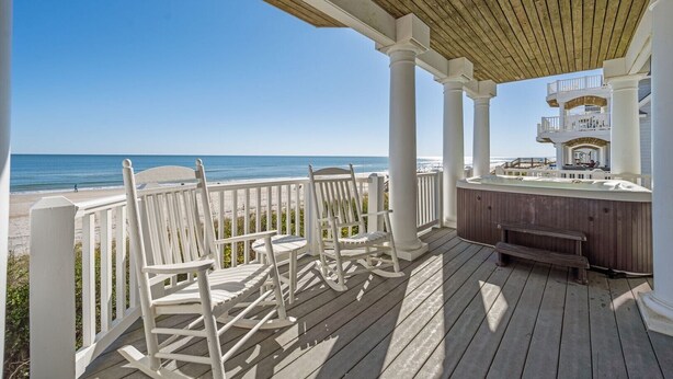A wooden deck with white chairs and a hot tub overlooking a beach. - 6BR Oceanfront House in North Topsail Beach w Hot Tub, Community Pool, Sleeps 15 (North Topsail Beach)