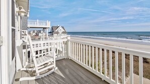 A wooden deck with a white railing overlooking a beach. - Island Drive 4158 (North Topsail Beach)