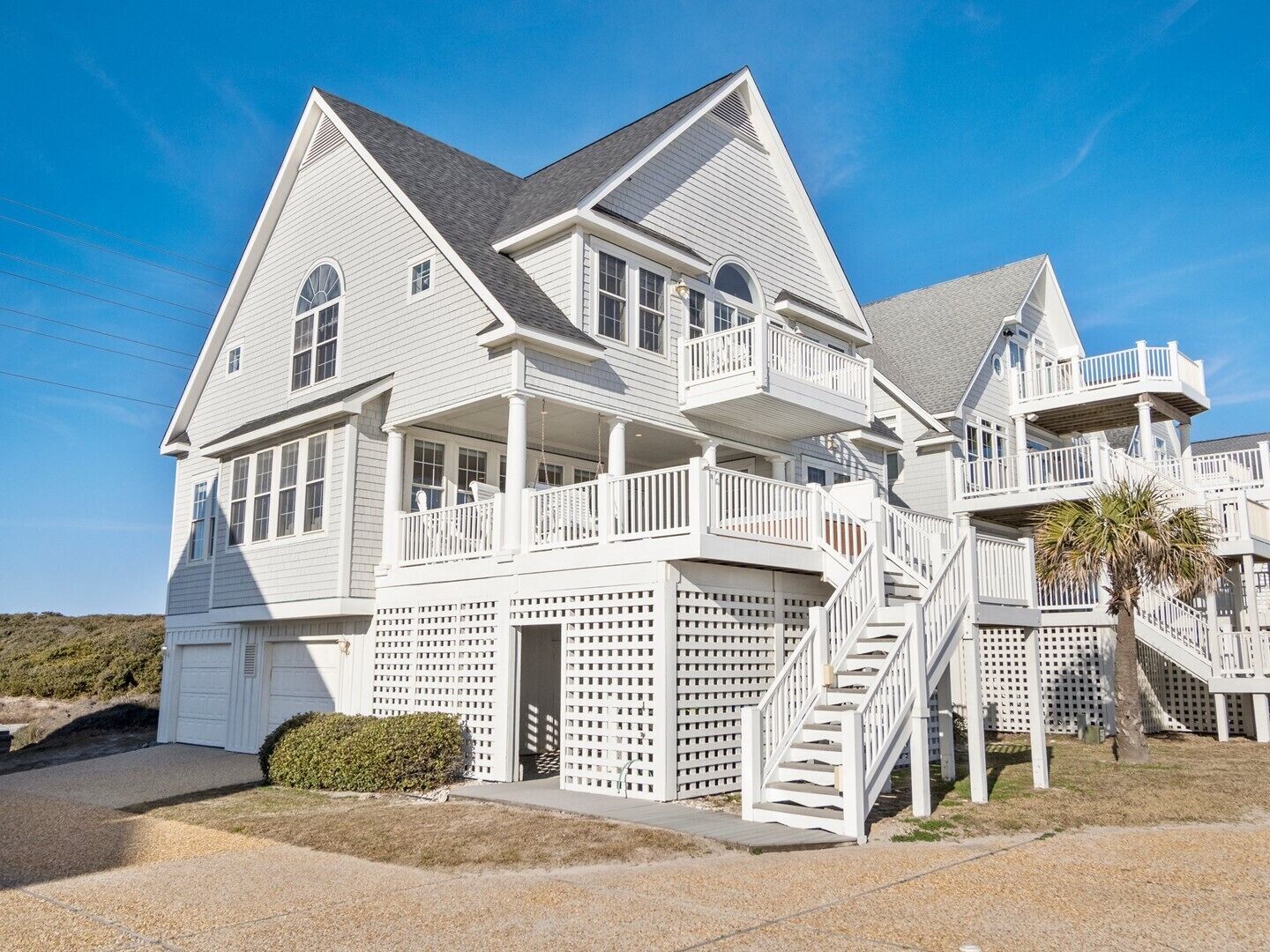 A large, two-story house with multiple balconies and a covered front porch.