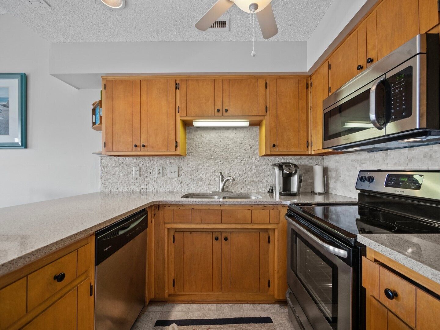 A kitchen with wooden cabinets, stainless steel appliances, and a granite countertop.