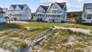 A beachfront property with multiple houses featuring balconies and a sandy beach area. - Island Drive 4180 (North Topsail Beach)