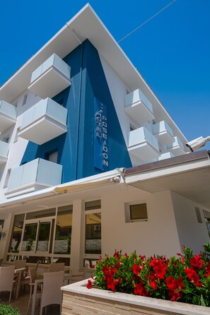A hotel with a modern design, featuring a prominent blue and white color scheme, outdoor seating area, and a visible sign indicating the hotel's name. - Hotel Poseidon e Nettuno (San Benedetto del Tronto)