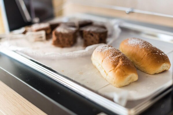 En køkkenbordplade med to boller og flere brownies på bagepapir.