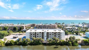 A coastal hotel with multiple buildings, a marina, and a view of the ocean. - Canal front Sanibel condo, short stroll to the Gulf of Mexico. (Sanibel)