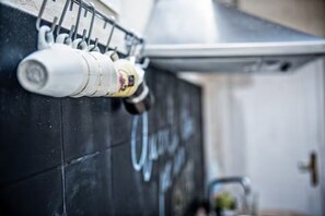 A tiled wall with a metal rack holding several white bottles, likely containing beverages.
