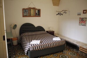 A bedroom with a bed, a bedside table, a hanging light fixture, and a wall-mounted picture. - Vacation home Caminanti - Historic center Lecce (Lecce)