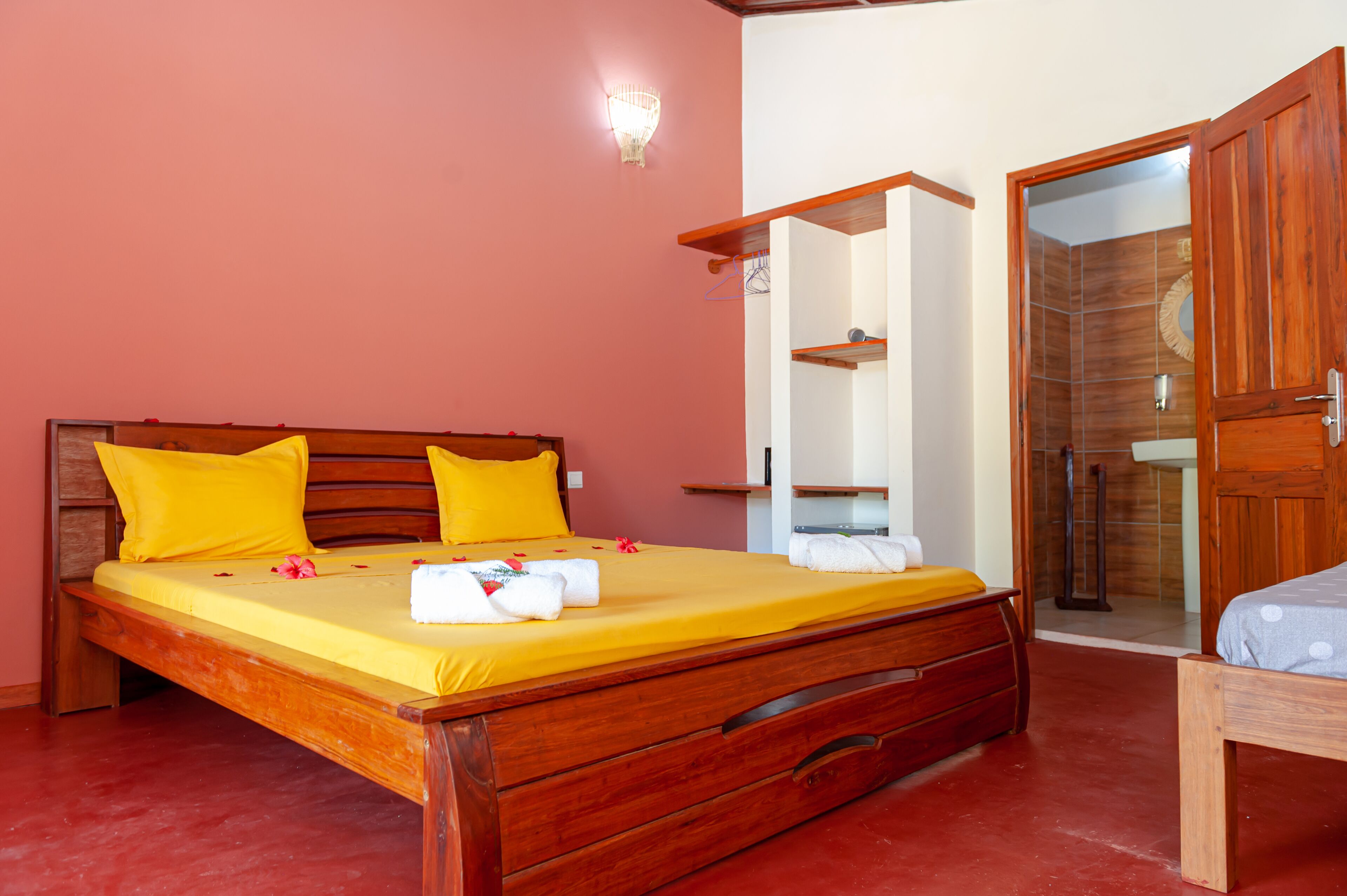 A neatly made bed with yellow bedding, wooden headboard, and two pillows.