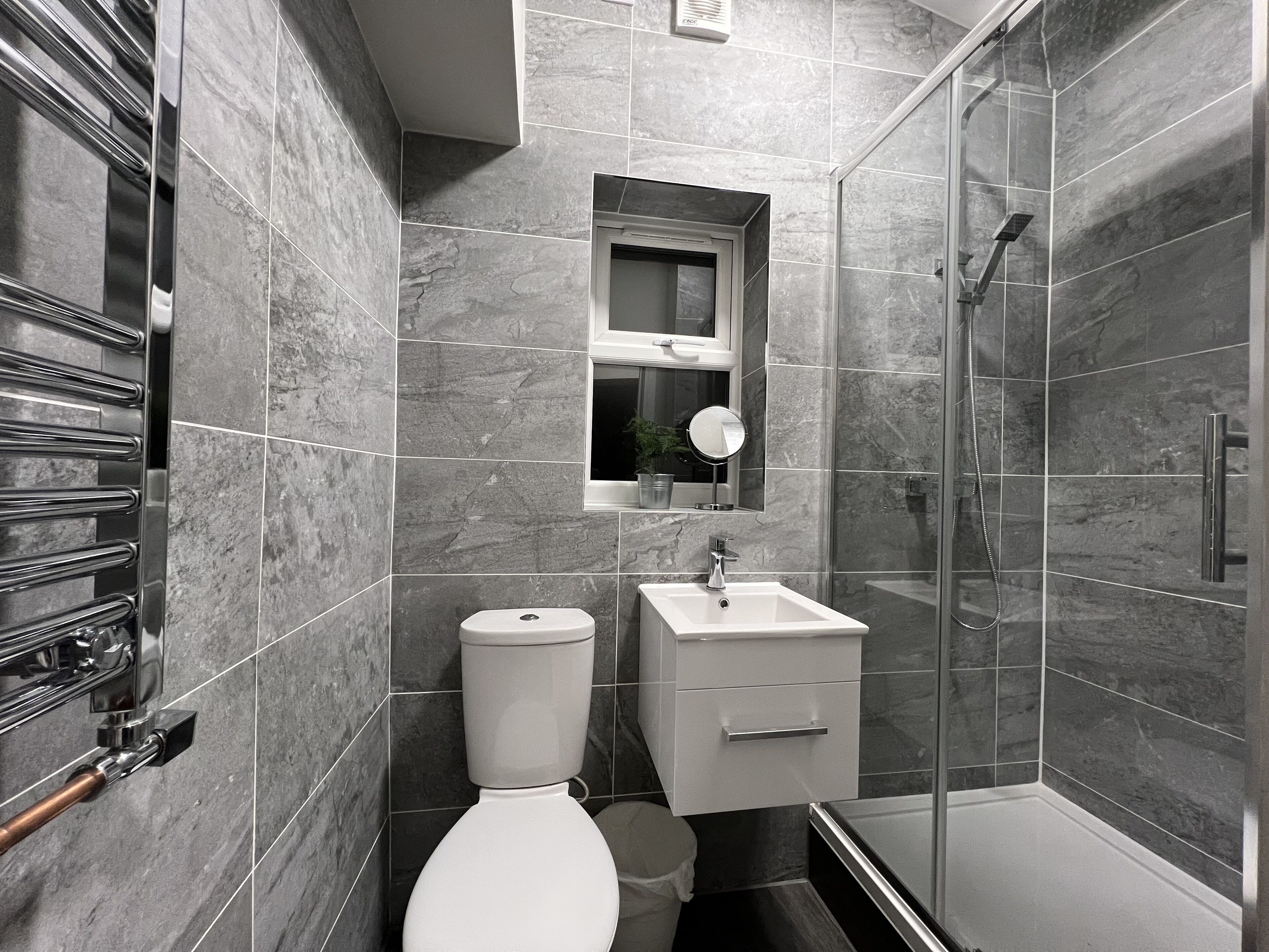 Ein modernes Badezimmer mit Toilette, Waschbecken und Dusche.
