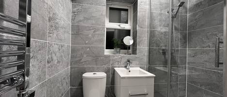 Ein modernes Badezimmer mit Toilette, Waschbecken und Dusche.