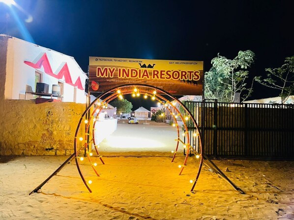 A sandy entrance area with a sign for 'MY INDIA RESORTS' and a camel silhouette. - My India Resorts (Jaisalmer)