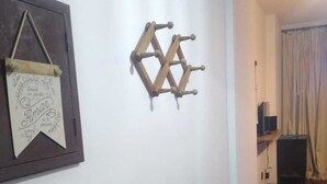 Een gang met een houten vloer, een houten wandrek en een lijst met tekst.