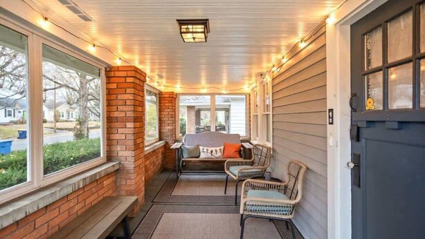 A covered porch with a bench, chairs, and a table. - Backyard+Porch, Pet-Friendly | Broad Ripple Stay (Indianapolis)