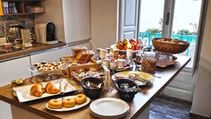 Un buffet de petit-déjeuner proposant des viennoiseries, des fruits et des boissons.