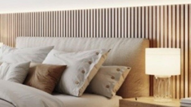 A bedroom with a bed, pillows, a bedside table with a lamp, and a wooden slat headboard. - Sea View Studio by Dominium (Dubrovnik)