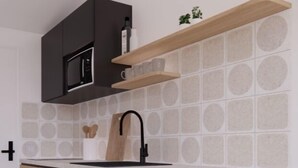 A modern kitchen with a microwave, wooden cabinets, a black faucet, and two black stools. - Sea View Studio by Dominium (Dubrovnik)