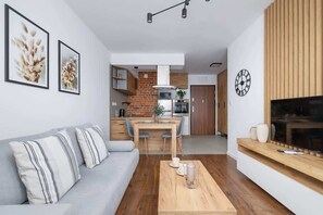Una sala de estar moderna con sofá, mesa de centro y una obra de arte en la pared.