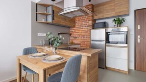 A modern kitchen with a central island, built-in appliances, and a brick accent wall.
