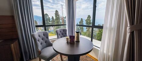 A room with a round table, two chairs, a coffee pot, and a menu.