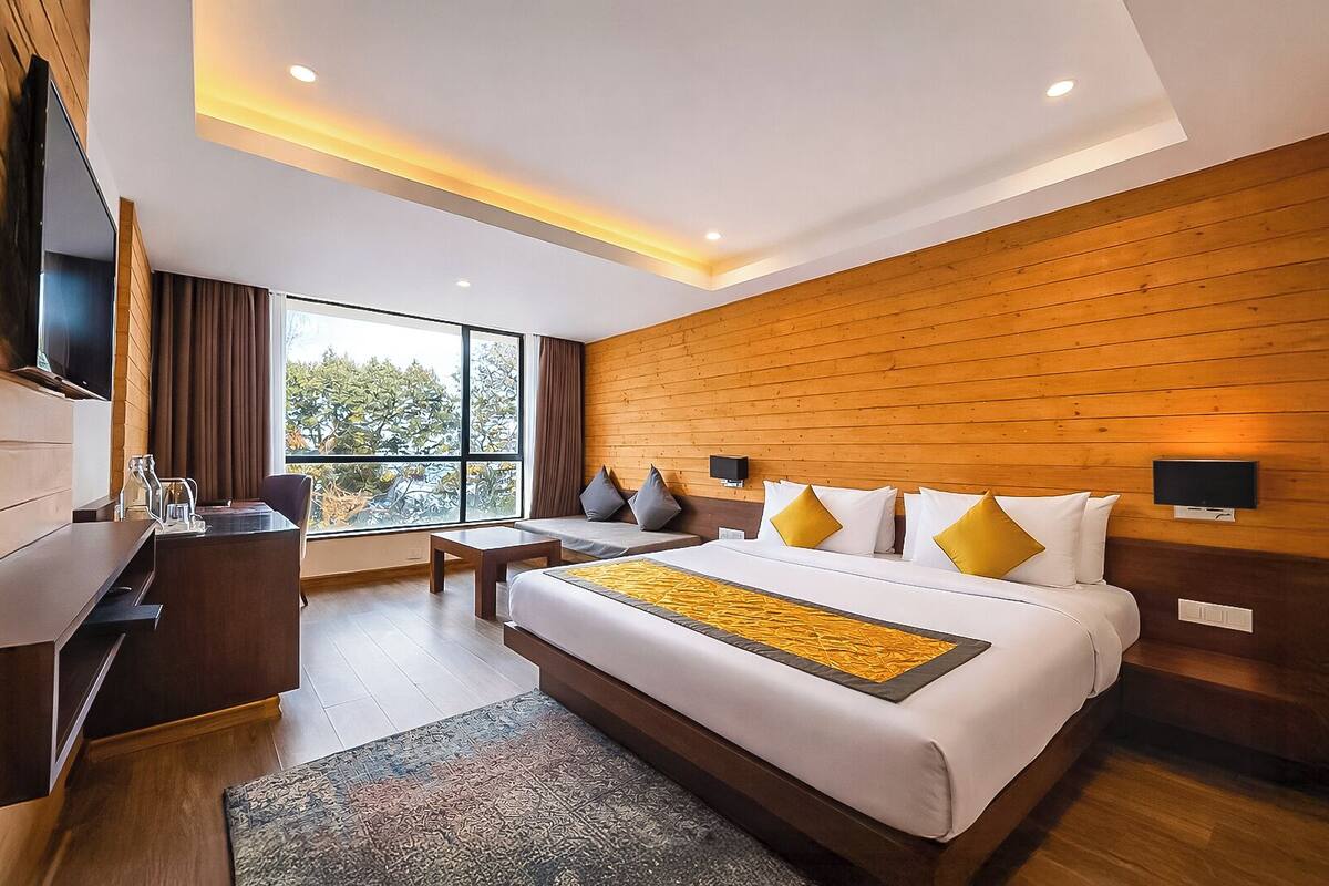 Una habitación de hotel moderna con una cama grande, un escritorio y un televisor.