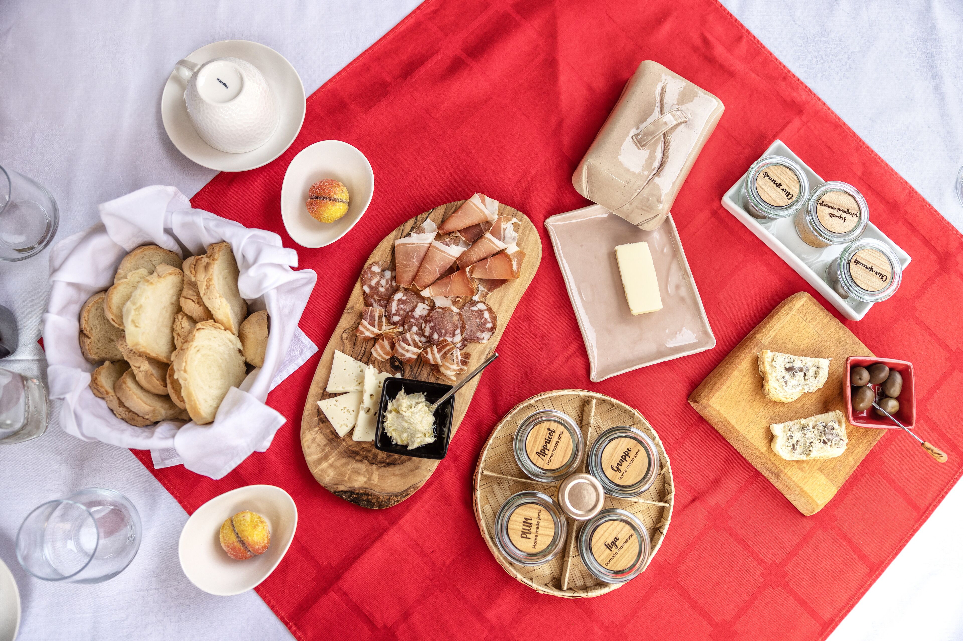 A table with various food items including bread, cheese, and jars of spreads.