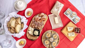 A table with various food items including bread, cheese, and jars of spreads.
