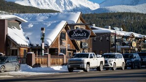 A mountain lodge with a sign reading "Ben's Mountain Bistro" and a wooden exterior.