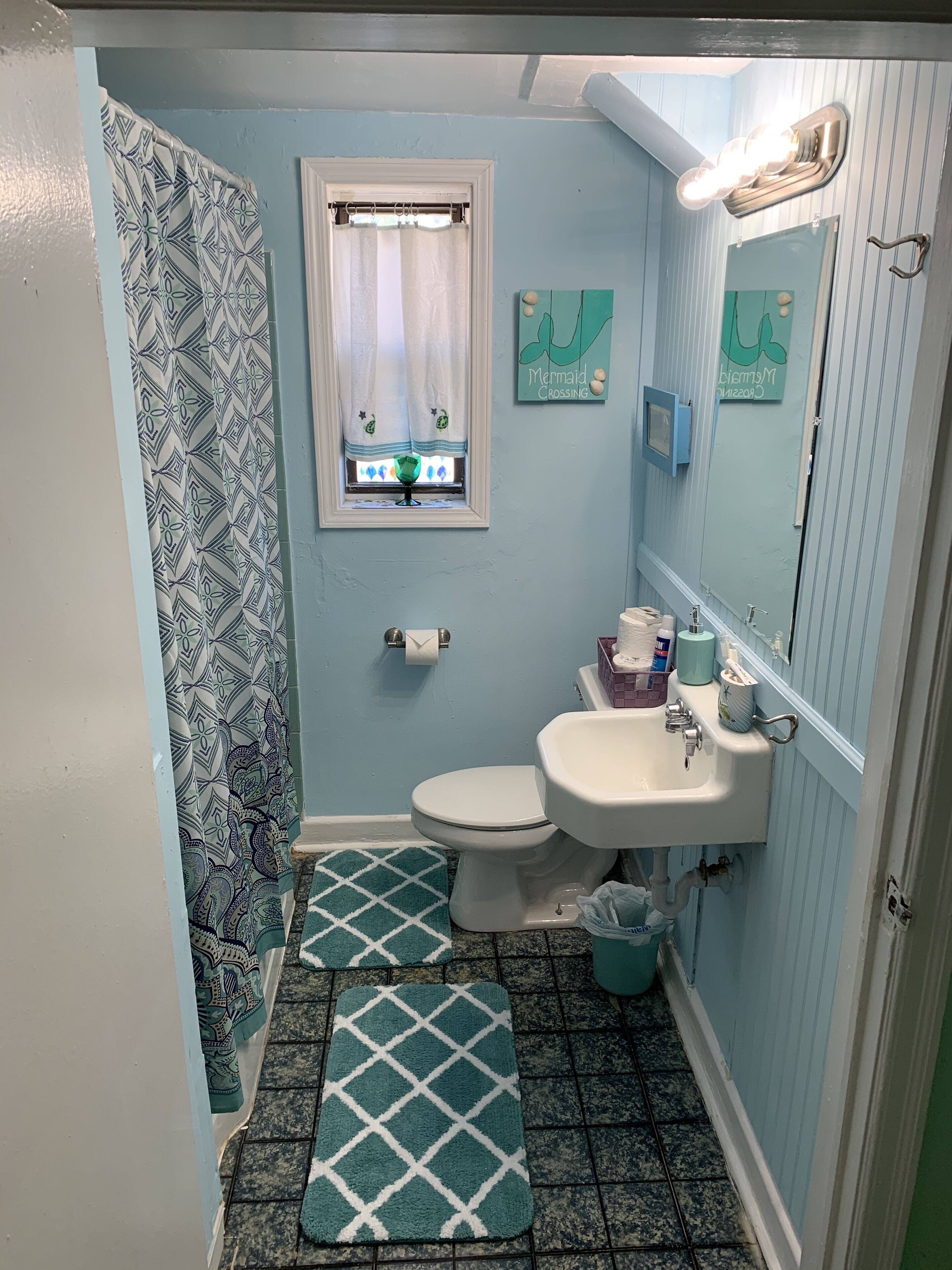 Un bagno con WC, lavandino e tenda per la doccia.