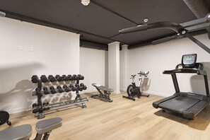 A gym with a treadmill, dumbbells, and an elliptical machine. - The Tokyo 1508 (Cape Town)