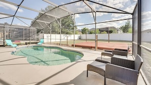 Ein überdachter Außenbereich mit Pool, Liegestühlen und einer Terrasse.