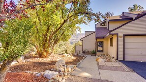 A two-story house with a driveway leading to a garage, surrounded by a landscaped garden with rocks and a tree. - Near Trails! Sun-drenched Durango Escape w/ View (Durango)