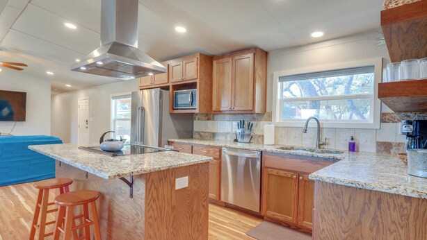 A modern kitchen with wooden cabinets, stainless steel appliances, and a granite countertop. - Pet-friendly Canyon Lake Home ~ 3 Mi to Water! (Canyon Lake)