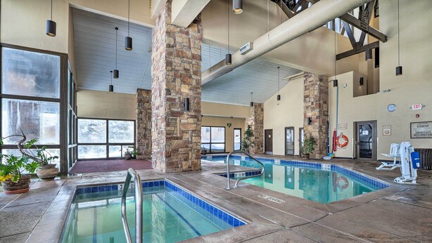 An indoor pool area with stone pillars, clear pool water, and a no diving sign. - Cozy Brian Head Condo: Walk to Navajo Express Lift (Brian Head)